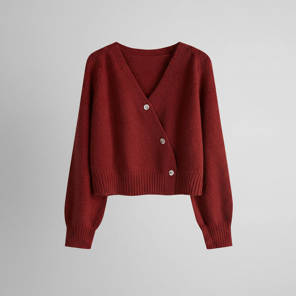 Red knitted cardigan with silver buttons on a white background