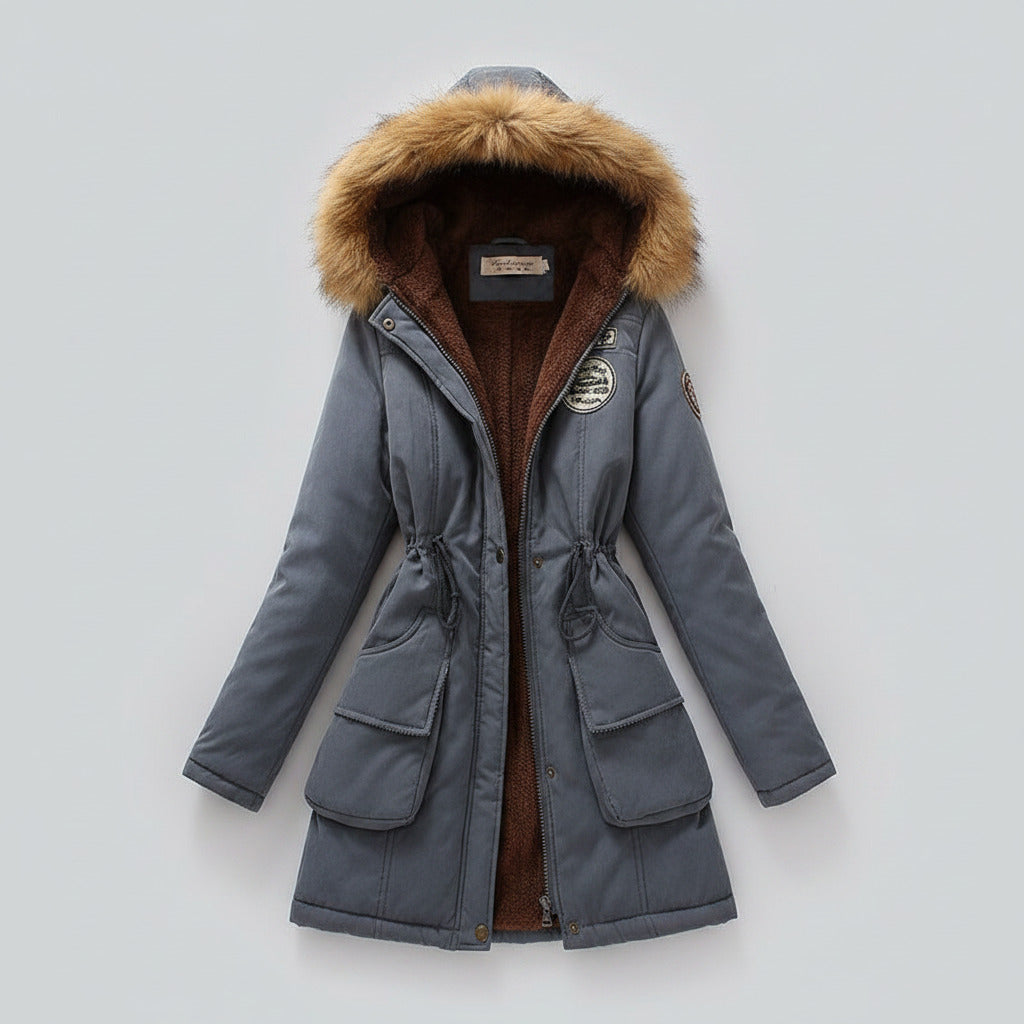 Blue winter coat with fur hood on a light beige background